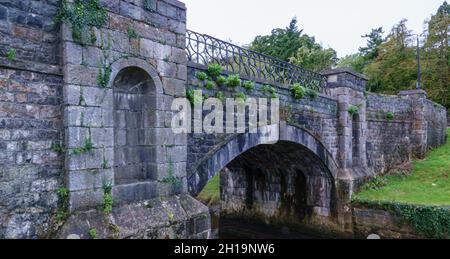 Eine Bogensteinbrücke, die über afon cegin im Penrhyn Dock, Bangor, Snowdonia Wales, Großbritannien, errichtet wurde Stockfoto