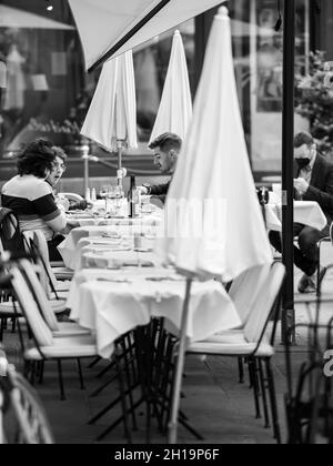 Seitenansicht der jungen Leute, die im ikonischen Restaurant Maison Kammerzell draußen essen Stockfoto