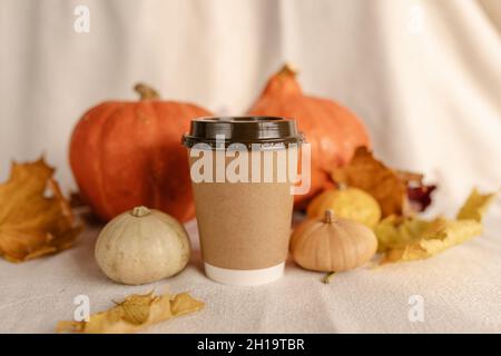 Kaffee Take Away Tasse im Herbst Kürbis aufgestellt. Kürbis-Latte mit Schlagsahne und frischem Zimt würzen. Kaffee zum trinken Stockfoto
