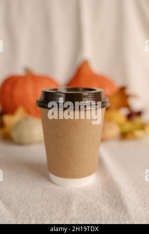 Kaffee Take Away Tasse im Herbst Kürbis aufgestellt. Kürbis-Latte mit Schlagsahne und frischem Zimt würzen. Kaffee zum trinken Stockfoto