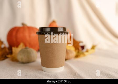Kaffee Take Away Tasse im Herbst Kürbis aufgestellt. Kürbis-Latte mit Schlagsahne und frischem Zimt würzen. Kaffee zum trinken Stockfoto