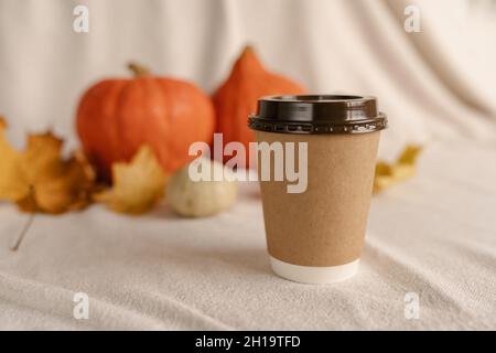 Kaffee Take Away Tasse im Herbst Kürbis aufgestellt. Kürbis-Latte mit Schlagsahne und frischem Zimt würzen. Kaffee zum trinken Stockfoto