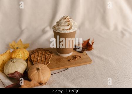 Kaffee Take Away Tasse im Herbst Kürbis aufgestellt. Kürbis-Latte mit Schlagsahne und frischem Zimt würzen. Kaffee zu Creme und Zimt auf der Oberseite zu gehen Stockfoto