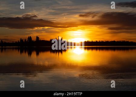 Sonnenuntergang über dem Astotin Lake Ende Oktober, Baumgrenze in der Ferne Stockfoto