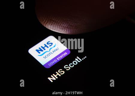 NHS Scotland App auf Smartphone und Finger berührt es gesehen. Selektiver Fokus. Konzept. Stafford, Großbritannien, 17. Oktober 2021. Stockfoto