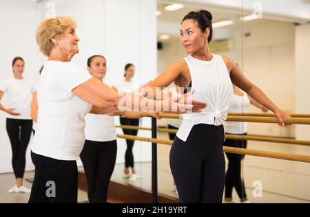 Frauen trainieren Ballettbewegungen mit Trainer Stockfoto