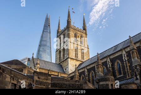 Im Kontrast zu alter und neuer Architektur: Der moderne Shard erhebt sich bei warmem Nachmittagslicht hinter einem historischen Uhrenturm der Southwark Cathedral, London SE1 Stockfoto