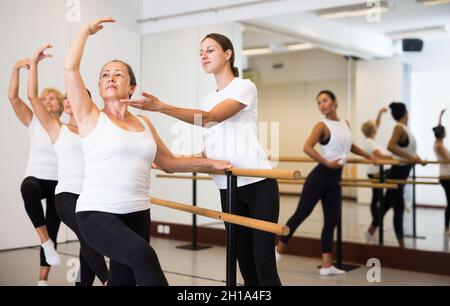 Frauen trainieren Ballettbewegungen mit Trainer Stockfoto