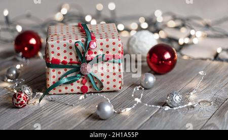 Weihnachtshintergrund mit Geschenkbox, Bällen auf dem Baum und Bokeh-Lichtern. Stockfoto