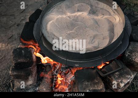 Der Sand wird auf dem Feuer erhitzt, um Kaffee zu machen. Stockfoto