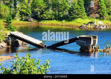 Eine alte Brücke spaltete sich in der Mitte und stürzte in einen Fluss, Trinity Bay, Neufundland, ein. Stockfoto