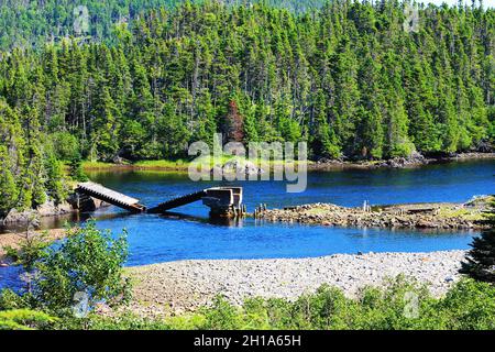 Eine alte Brücke spaltete sich in der Mitte und stürzte in einen Fluss, Trinity Bay, Neufundland, ein. Stockfoto