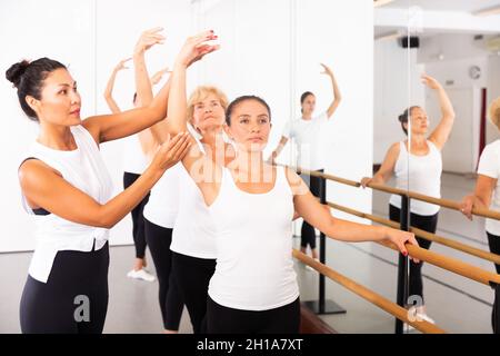 Frauen trainieren Ballettbewegungen mit Trainer Stockfoto