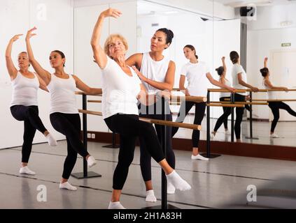 Frauen trainieren Ballettbewegungen mit Trainer Stockfoto