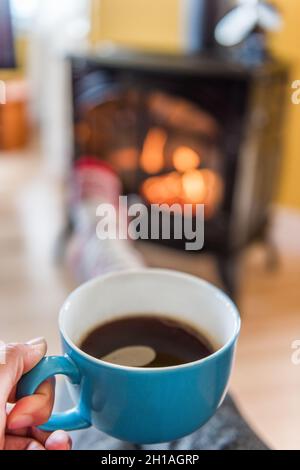Gemütliche Kamin Herbst Frau trinken Kaffee Stockfoto