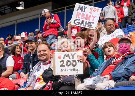 Harrison, USA. Oktober 2021. Eine Dame, Fan von Red Bulls, feiert ihr 200. Spiel, während ein junger Fan sein erstes Spiel im Stadion während des regulären MLS-Spiels zwischen Red Bulls und NYCFC in der Red Bull Arena in Harrison, New Jersey, am 17. Oktober 2021 feiert. Das Spiel bekannt als Hudson River Derby oder New York Derby, weil beide Teams aus New York haben Basen auf der anderen Seite des Flusses. Red Bulls gewann das Spiel 1 - 0 und erhöhte ihre Chancen für die Nachsaison. (Foto von Lev Radin/Sipa USA) Quelle: SIPA USA/Alamy Live News Stockfoto