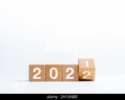 Die Jahreszahlen für den Wechsel vom Kalenderjahr 2021 wurden auf Holzwürfelblöcken, isoliert auf weißem Hintergrund mit Kopierraum, auf 2022 geändert, einfach Stockfoto