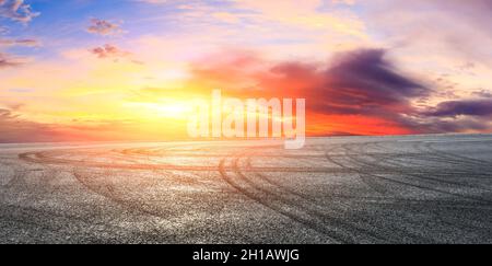 Asphalt Rennbahn Straße und Himmel Wolken bei Sonnenuntergang.Straße Boden Hintergrund. Stockfoto