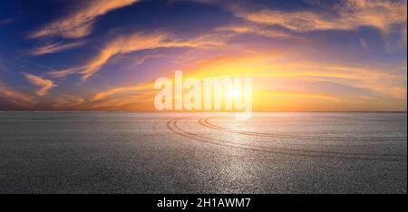 Asphalt Rennbahn Straße und Himmel Wolken bei Sonnenuntergang.Straße Boden Hintergrund. Stockfoto