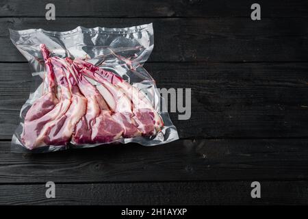 Lamb Rib Vakuum versiegelt bereit für sous vide Koch-Set, auf schwarzem Holztisch Hintergrund, mit Copyspace und Platz für Text Stockfoto