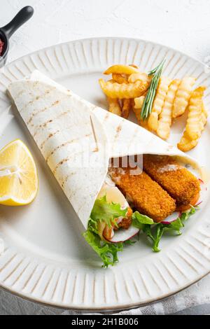 Tortilla-Rolle mit Fischfinger, Käse- und Gemüseset, auf Teller, auf weißem Hintergrund Stockfoto