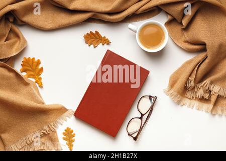 Herbstkonzept. Büchergläser beige Kaschmir Schal Kaffeetasse mit getrockneten Ahornblättern auf grauem Hintergrund. Flach liegend, Draufsicht Stockfoto