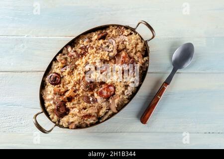 Risotto ai funghi, Pilzreis, oben auf einem Holzhintergrund mit einem Löffel geschossen Stockfoto