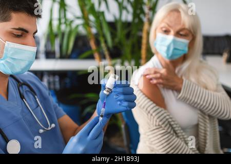 Dr. Holding Spritze Mit Covid-19-Impfstoff Für Reife Weibliche Patienten Stockfoto