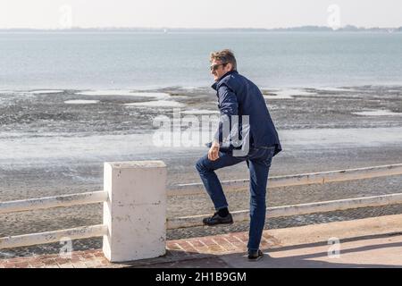 Mann, der den Strand von der Meereswand von Crotoy in der Somme-Bucht aus beobachtet Stockfoto