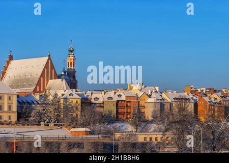 Wintersonnenaufgang in der Stadt Warschau, der Hauptstadt Polens. Verschneite Dächer der historischen Häuser der Altstadt und der Erzkathedrale von St. John. Stockfoto