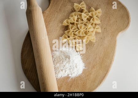 Gesunde Ernährung. Butterfly Paste und Nudelholz auf einem Holzbrett Stockfoto