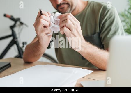 Telearbeiter mit kreativem Block im Heimbüro zerbröckelnde Papierblätter, selektiver Fokus Stockfoto