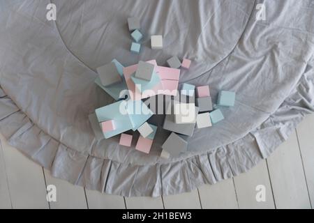 Bunte Spielzeugwürfel in Pastellfarben auf dem Teppich im Kinderzimmer, Draufsicht Stockfoto