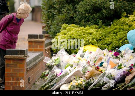 Eine Frau hält an, um sich Blumen und Ehrungen anzusehen, die vor der Methodistischen Kirche von Belfairs in der Eastwood Road North, Leigh-on-Sea, Essex, zurückgelassen wurden, wo der konservative Abgeordnete Sir David Amess starb, nachdem er am Freitag während einer Wahlkreisoperation mehrmals erstochen wurde. Bilddatum: Montag, 18. Oktober 2021. Stockfoto