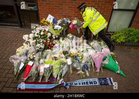 Ein Polizeibeamter arrangiert Blumen und Ehrungen vor der Methodistischen Kirche von Belfairs in der Eastwood Road North, Leigh-on-Sea, Essex, wo der konservative Abgeordnete Sir David Amess starb, nachdem er am Freitag während einer Wahlkreisoperation mehrmals erstochen wurde. Bilddatum: Montag, 18. Oktober 2021. Stockfoto