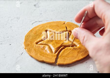 Dalgona Candy: Südkoreanische Gaumenfreude. Runder Zuckerkekse mit einem Stern im Inneren. Stockfoto