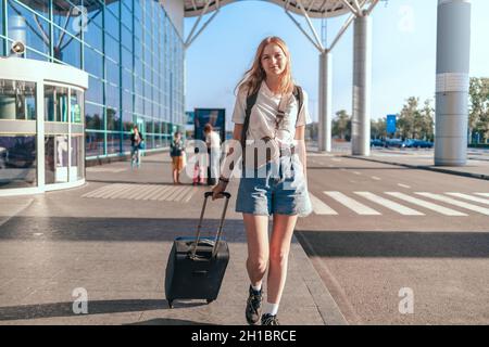 Junge Touristenfrau mit Gepäck auf dem internationalen Flughafen für die Reise. Stockfoto