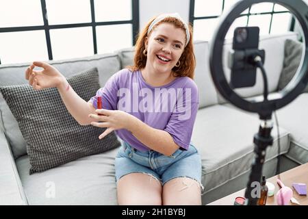 Junge Rotschopf Frau Make-up-Tutorial mit Smartphone zu Hause Stockfoto
