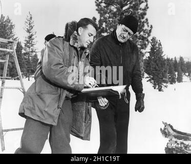 JOHN WAYNE am Drehort offen mit Script Supervisor SAM FREEDLE während der Dreharbeiten von ISLAND IN THE SKY 1953 Regisseur WILLIAM A. WELLMAN Drehbuch Ernest K. Gann Wayne-Fellows Productions / Warner Bros Stockfoto