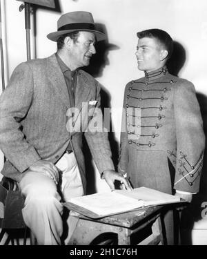 JOHN WAYNE besucht seinen 15-jährigen Sohn PATRICK WAYNE in Kostüm als Cadet bei seinem ersten Filmauftritt am Set Candid im April 1954 während der Dreharbeiten DES REGISSEURS JOHN FORD Rota Productions / Columbia Picturs der LANGEN GRAUEN LINIE 1955 Stockfoto
