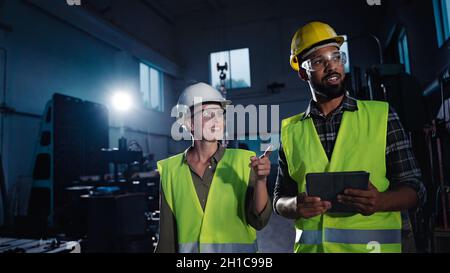 Porträt von Industrieinspektoren, die in Innenräumen in einer Metallwerkstatt eine allgemeine Überprüfung durchführen. Stockfoto