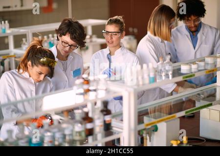 Junge Studenten arbeiten gerne in einer sterilen Laborumgebung. Wissenschaft, Chemie, Labor, Menschen Stockfoto