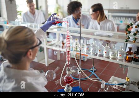 Junge Chemiestudenten haben eine gute Zeit, während sie an einem Experiment in einem Labor in einer entspannten Atmosphäre arbeiten. Wissenschaft, Chemie, Labor, Menschen Stockfoto