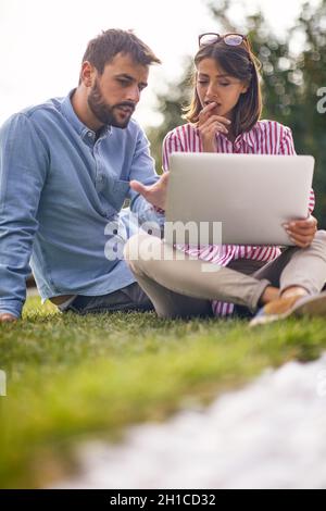 Zwei Studenten beraten sich gemeinsam in einem Hof für ein Papier Stockfoto