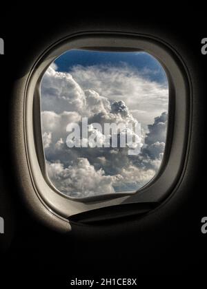 Wolkenlandschaft durch ein fliegendes Flugzeugfenster gesehen Stockfoto