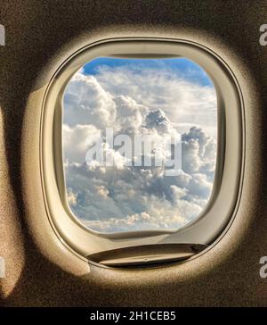 Wolkenlandschaft durch ein fliegendes Flugzeugfenster gesehen Stockfoto