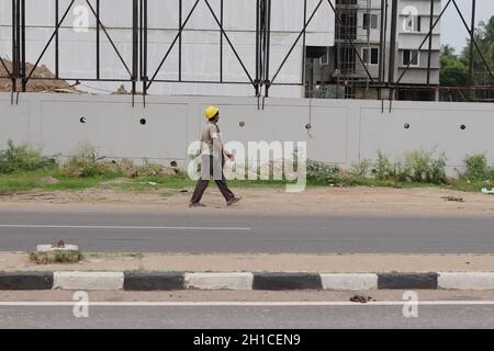 Chennai Tamil nadu, Indien -18 Okt 2021.Ein Arbeiter, der mit einem Schutzhelm unterwegs ist Stockfoto