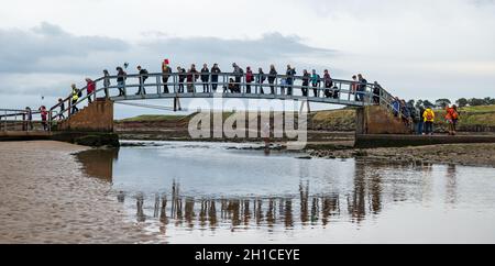 Belhaven Bay, East Lothian, Schottland, Großbritannien, 18. Oktober 2021. Cop26 Pilgerfahrt: Nach einem Zwischenstopp in Dunbar starten christliche Klimaaktivisten auf die erste Etappe des John Muir Way. Sie überqueren die Brücke nach Nowhere und gehen bei Ebbe über den Strand. Die Pilgerfahrt wird Ende des Monats zur COP26 in Glasgow gehen Stockfoto