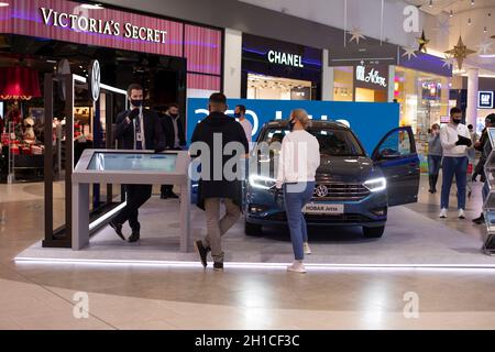 Moskau, Russland - 16. November 2020: Präsentation des Volkswagen Jetta Autos, Messestand mit blauem Auto. Maskierte Menschen Stockfoto