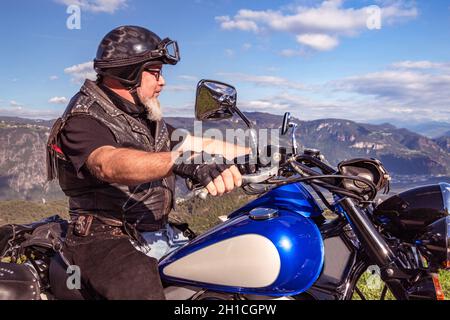 Kerl auf einem Retro-Cruiser-Motorrad auf Bergstraße in Südtirol genießen die schöne Aussicht Stockfoto